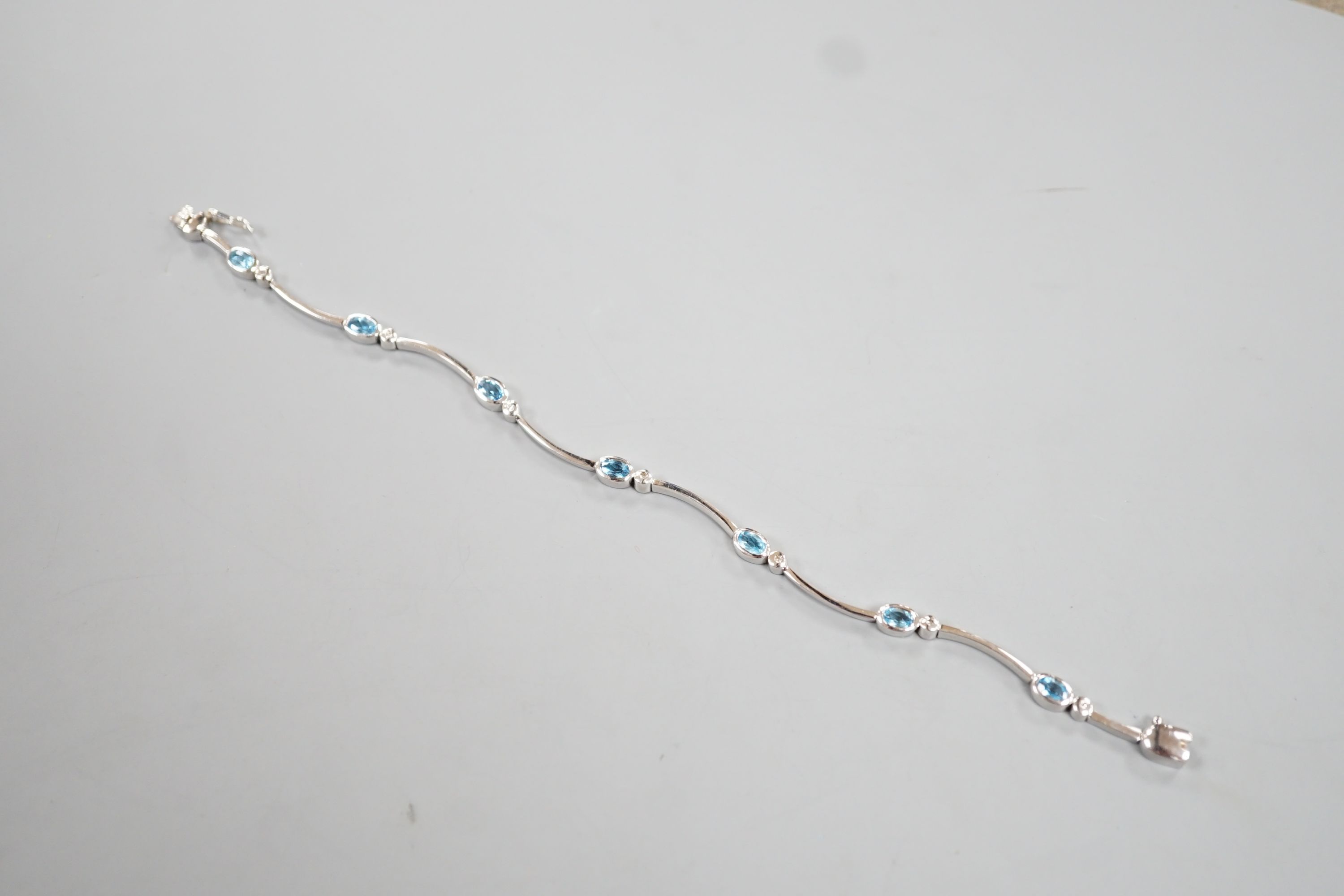 A modern 9ct white gold, blue topaz? and diamond chip set bracelet, 18.5cm, gross 8.8 grams.